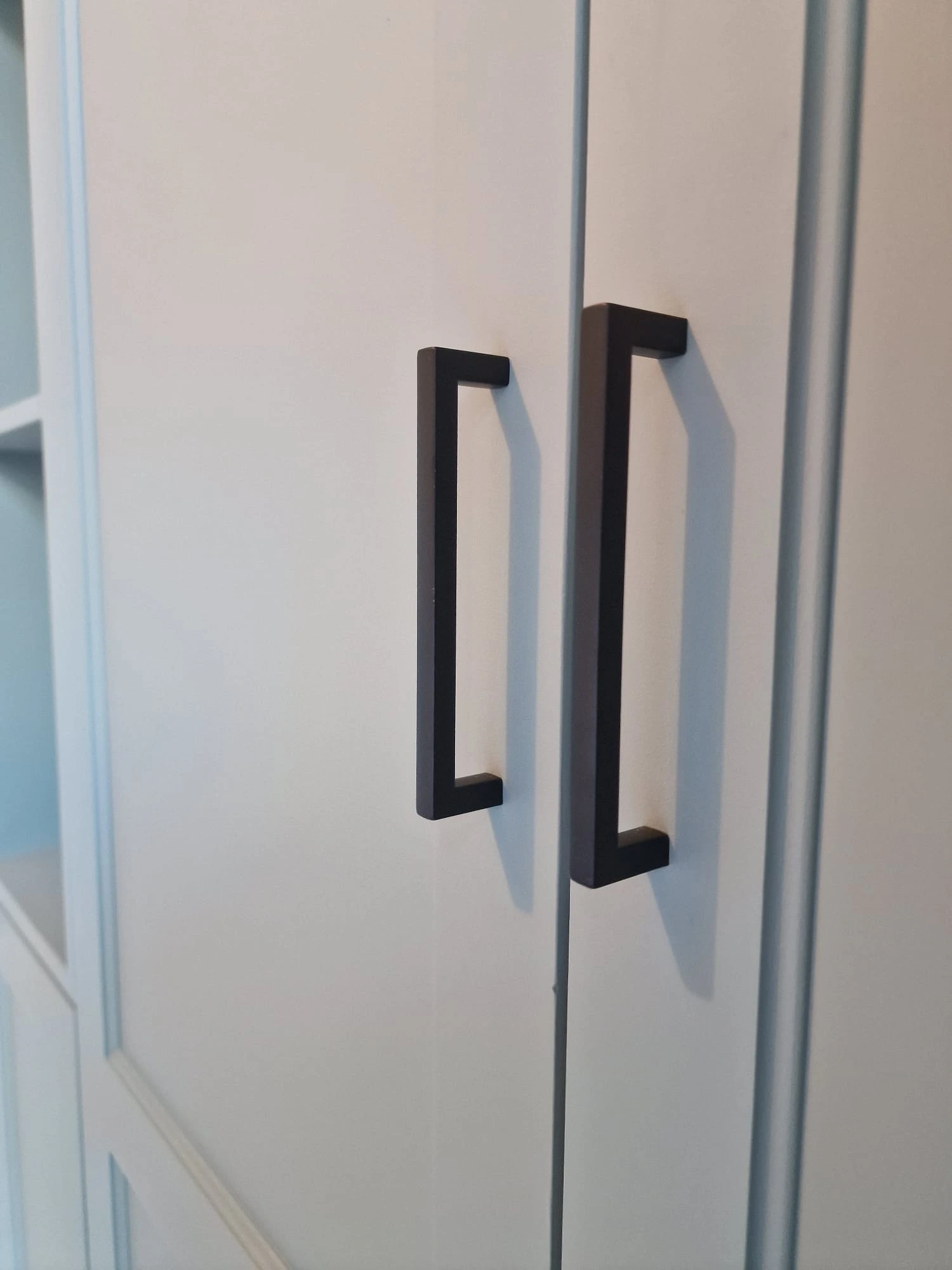 Garderobslösning med svarta handtag